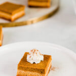 Top view of keto pumpkin pie bar on a white plate with a fork