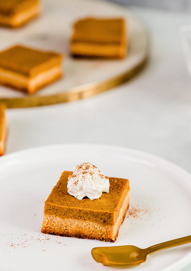 Top view of keto pumpkin pie bar on a white plate with a fork